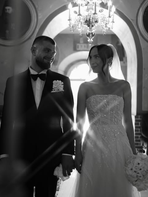 A bride and groom beneath a chandelier