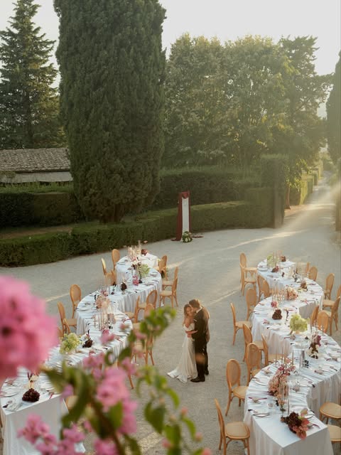 A couple surrounded by curved tables in a sunlit garden