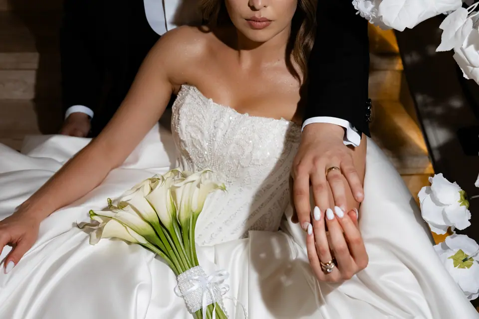 Detail of Alexandra’s calla lily bouquet and the couple’s hands with their rings