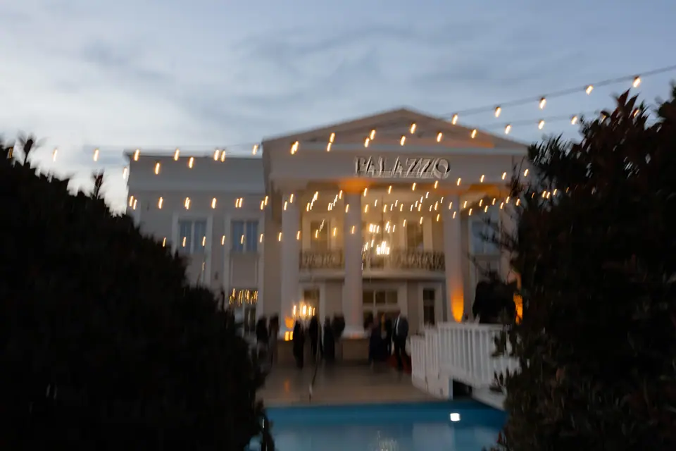 The venue lit up at dusk beneath strings of lights