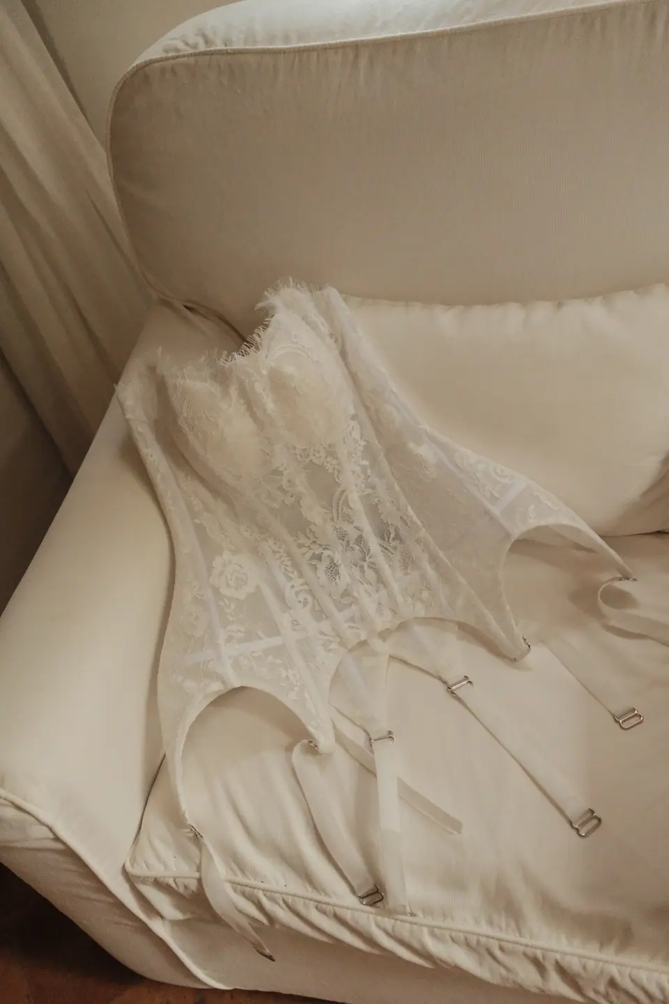 Ana’s lace corset laid out on a white armchair