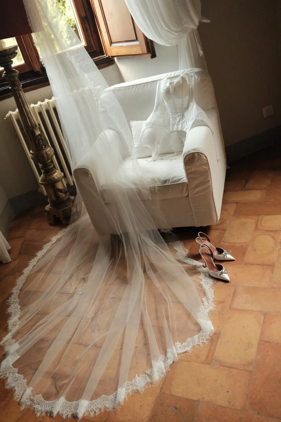 Ana’s cathedral veil spread across the terracotta floor beside her shoes