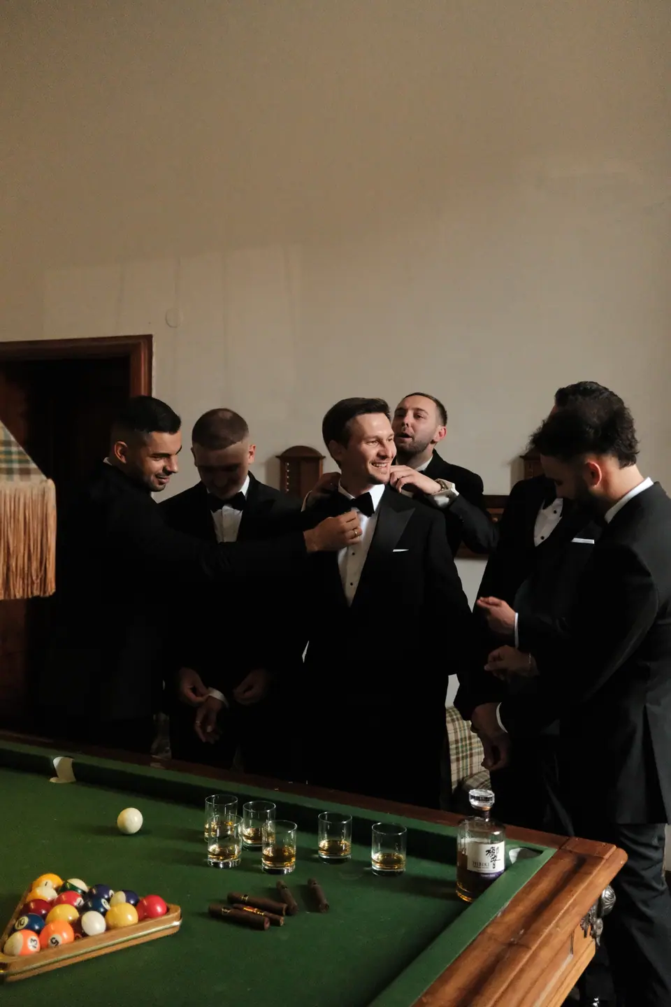 Silviu and his groomsmen sharing a whiskey around the billiard table
