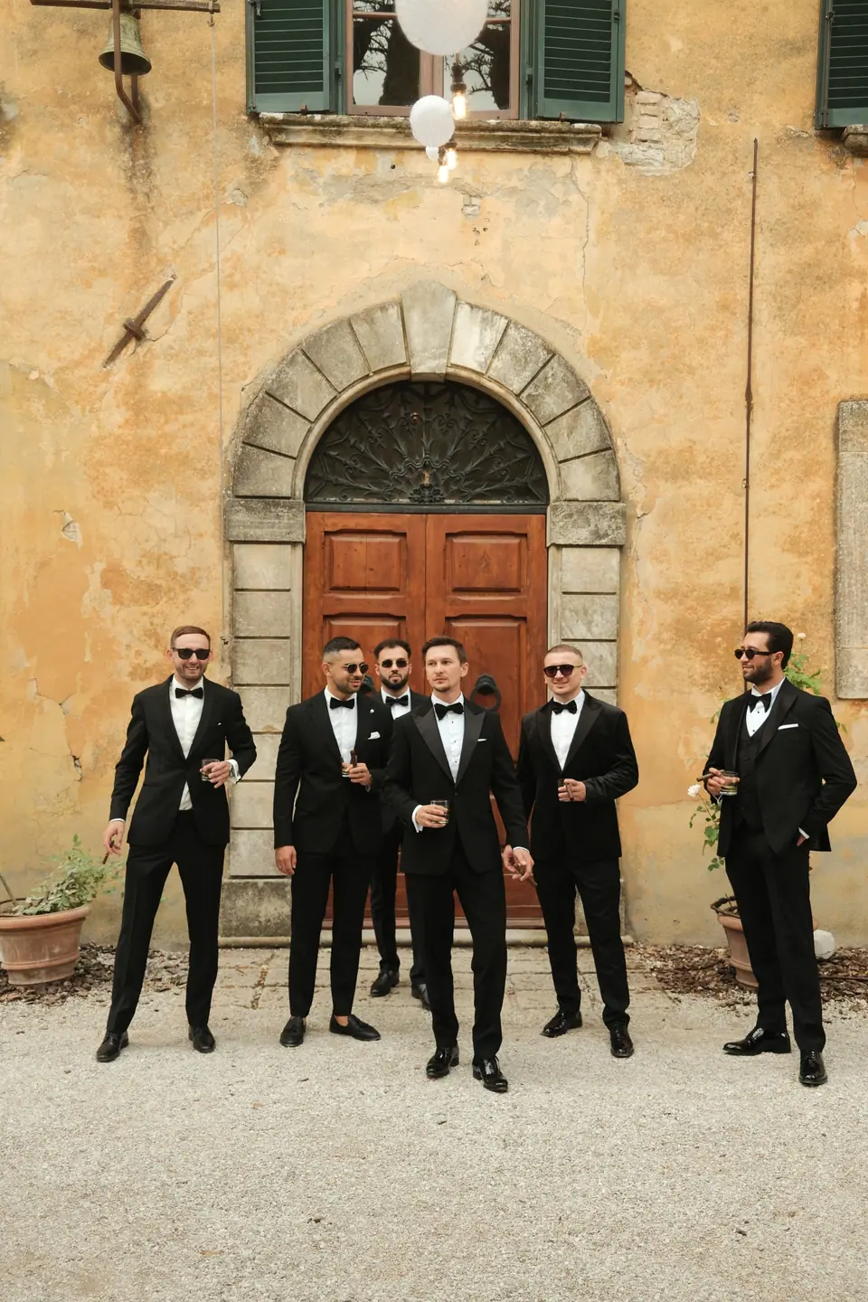 Silviu and his groomsmen in front of the villa’s arched wooden door