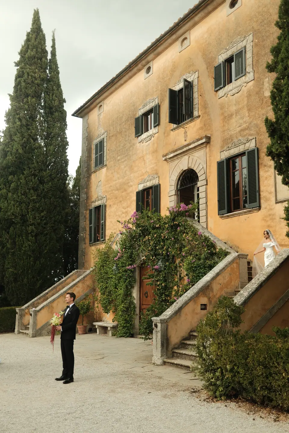 Silviu waiting in the courtyard as Ana appears at the top of the villa steps