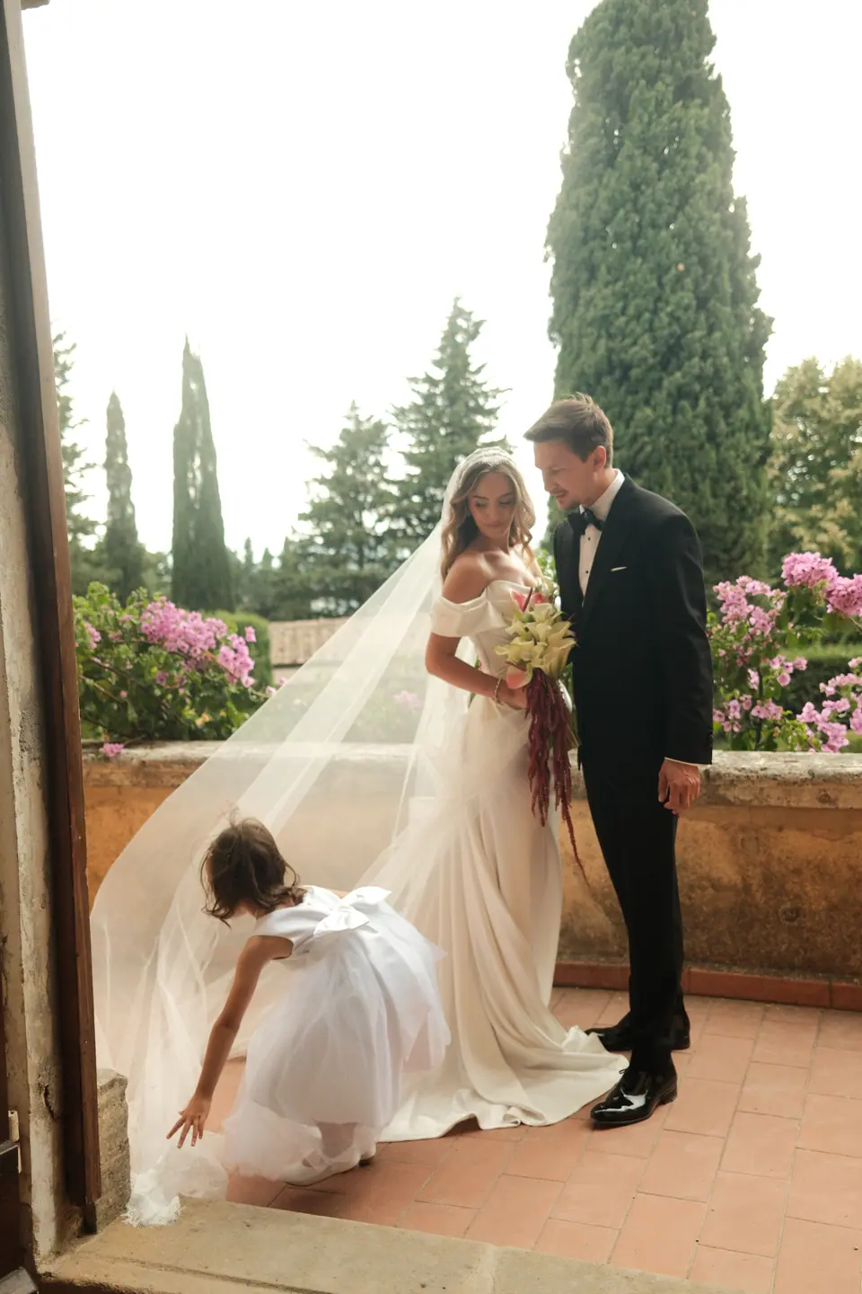 A bridesmaid arranging Ana’s veil on the terrace as she meets Silviu