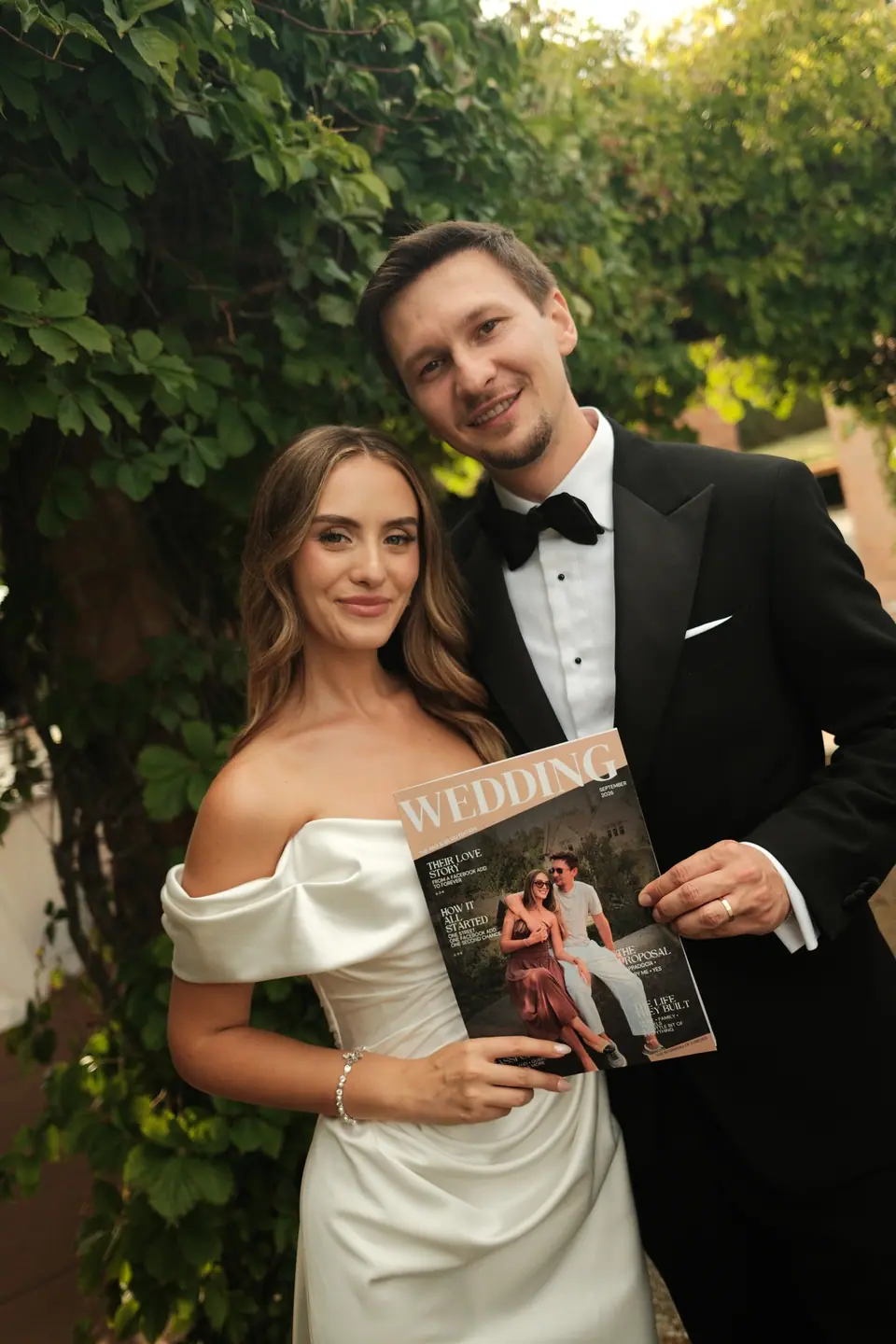 Ana and Silviu holding a wedding magazine with their own photo on the cover