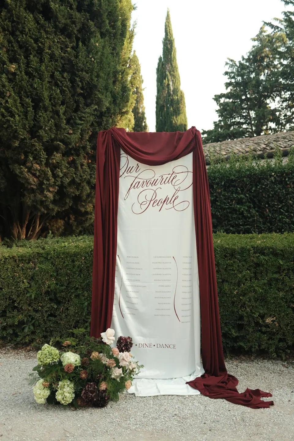 A seating chart reading “Our favourite People”, draped in burgundy fabric