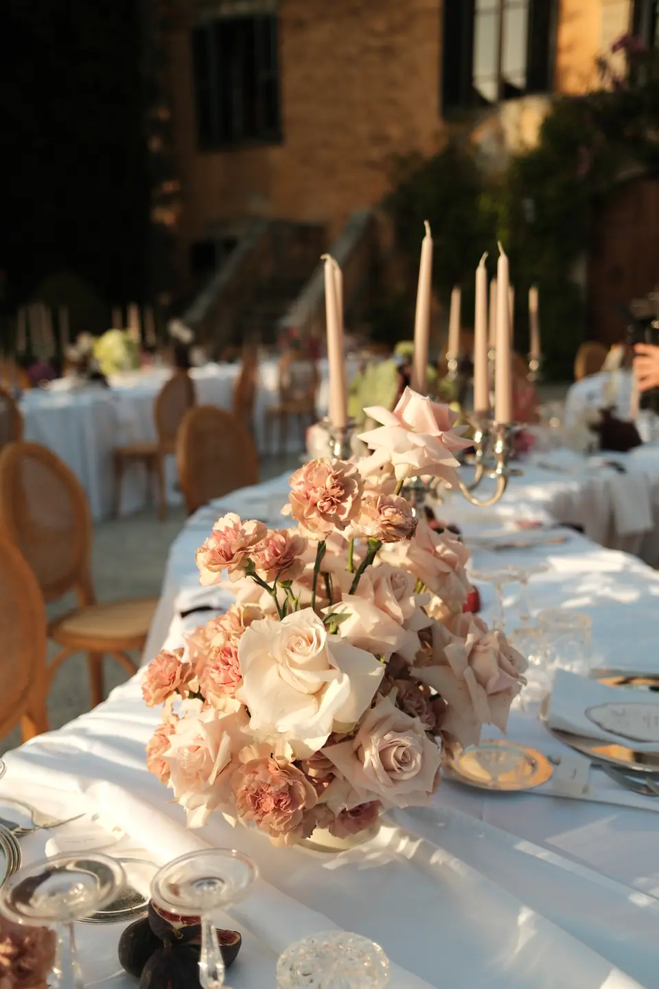 Tapered candles and roses on the dinner tables in front of the villa