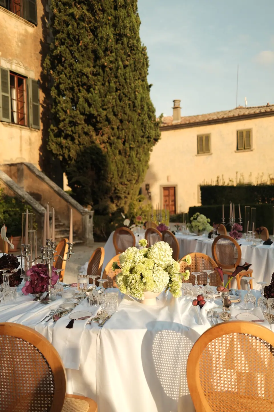 Hydrangea centrepieces and candelabras on the courtyard tables