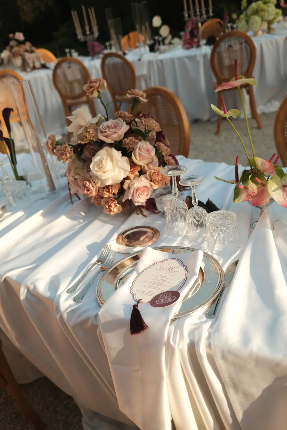 A set table with a rose centrepiece and the tasselled menu