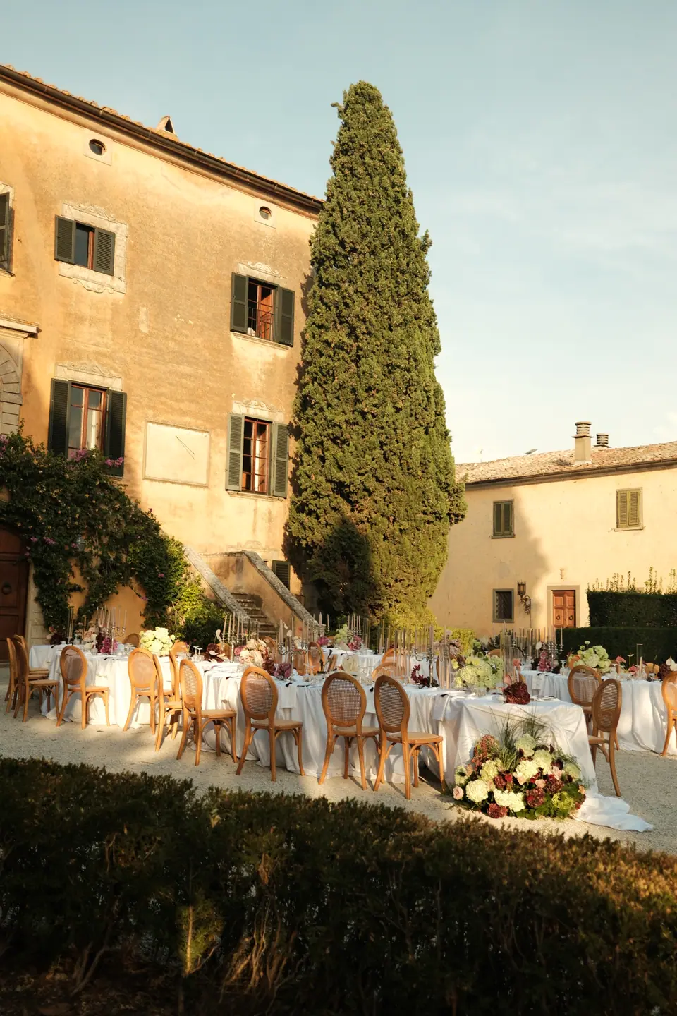 The villa courtyard set for dinner as evening light falls