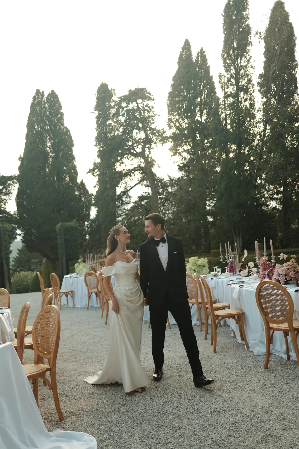 Ana and Silviu walking hand in hand between the dinner tables