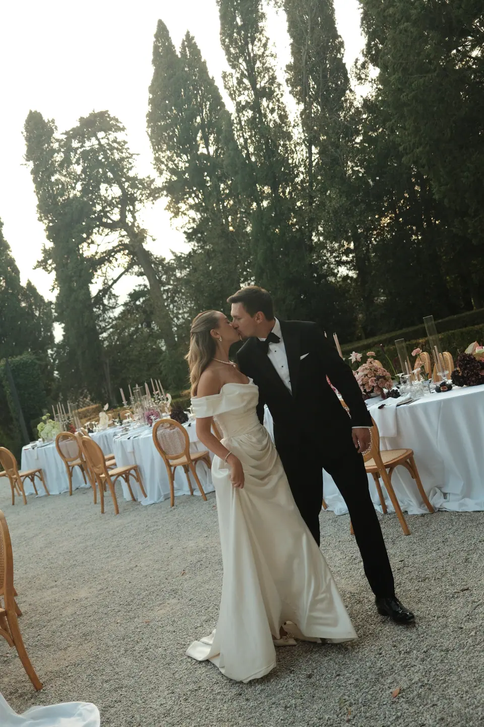 Ana and Silviu kissing among the dinner tables on the villa terrace