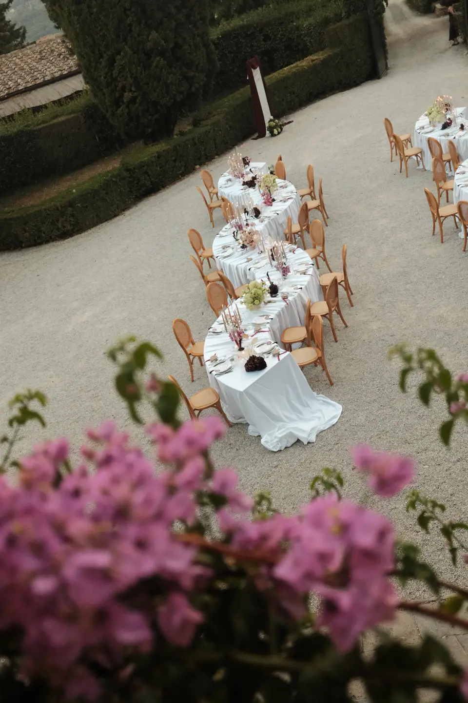 The courtyard tables seen past pink bougainvillea