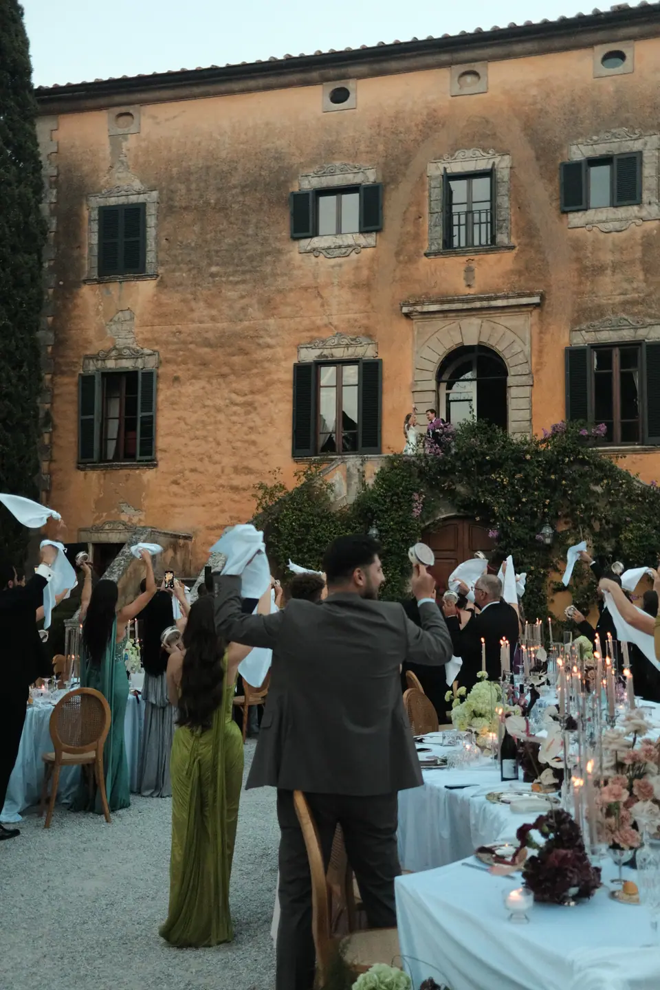 Guests waving napkins in the air beside the villa