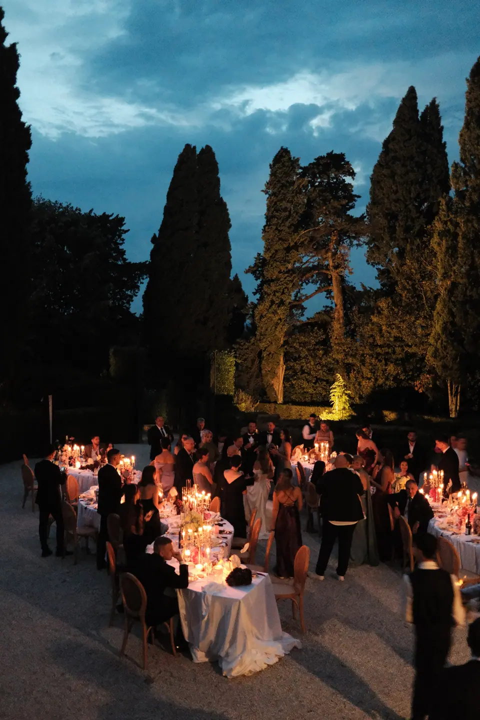 The candlelit courtyard dinner under a deep blue evening sky