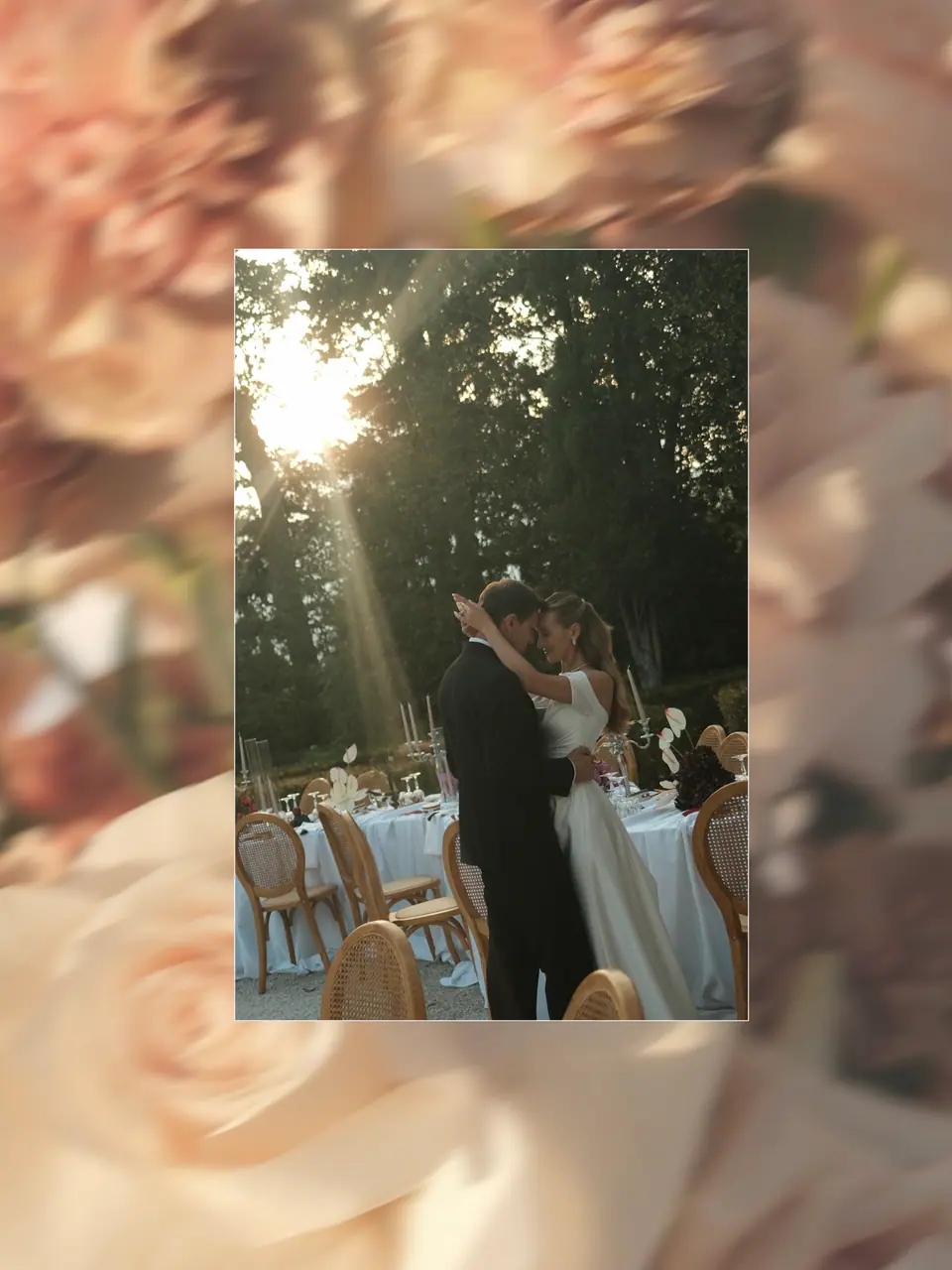 Ana and Silviu kissing in a ray of sun among the tables, framed in blurred roses