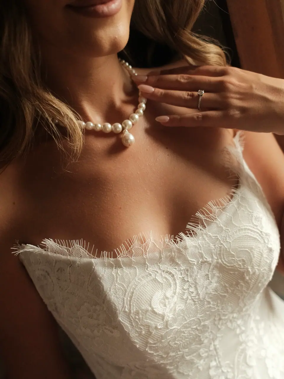 Close-up of Ana’s pearl necklace and the lace neckline of her dress