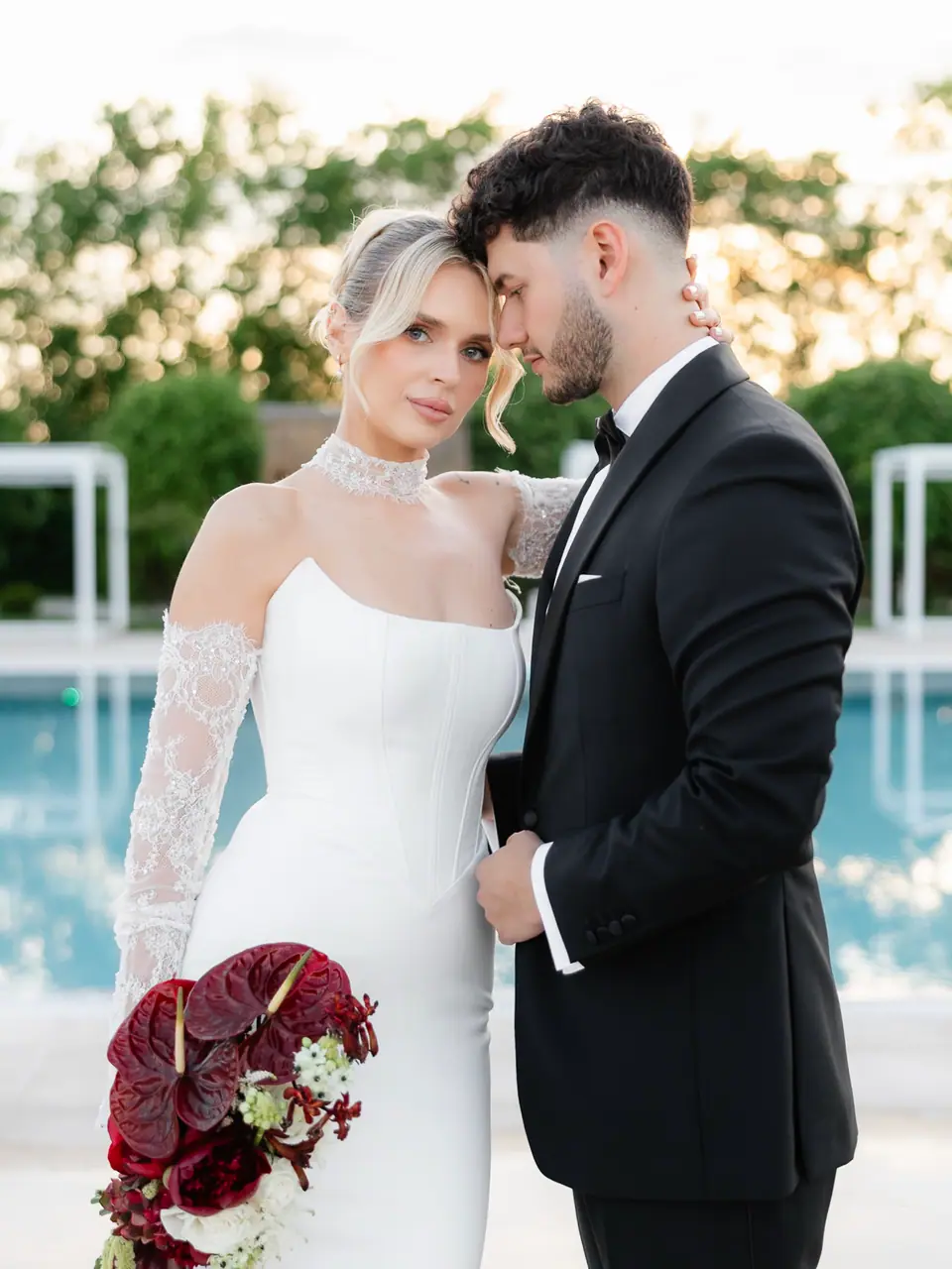 Andreea holding a red bouquet as Bogdan leans his forehead to hers beside the pool