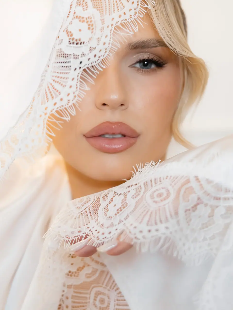 Andreea looking out from beneath her lace veil