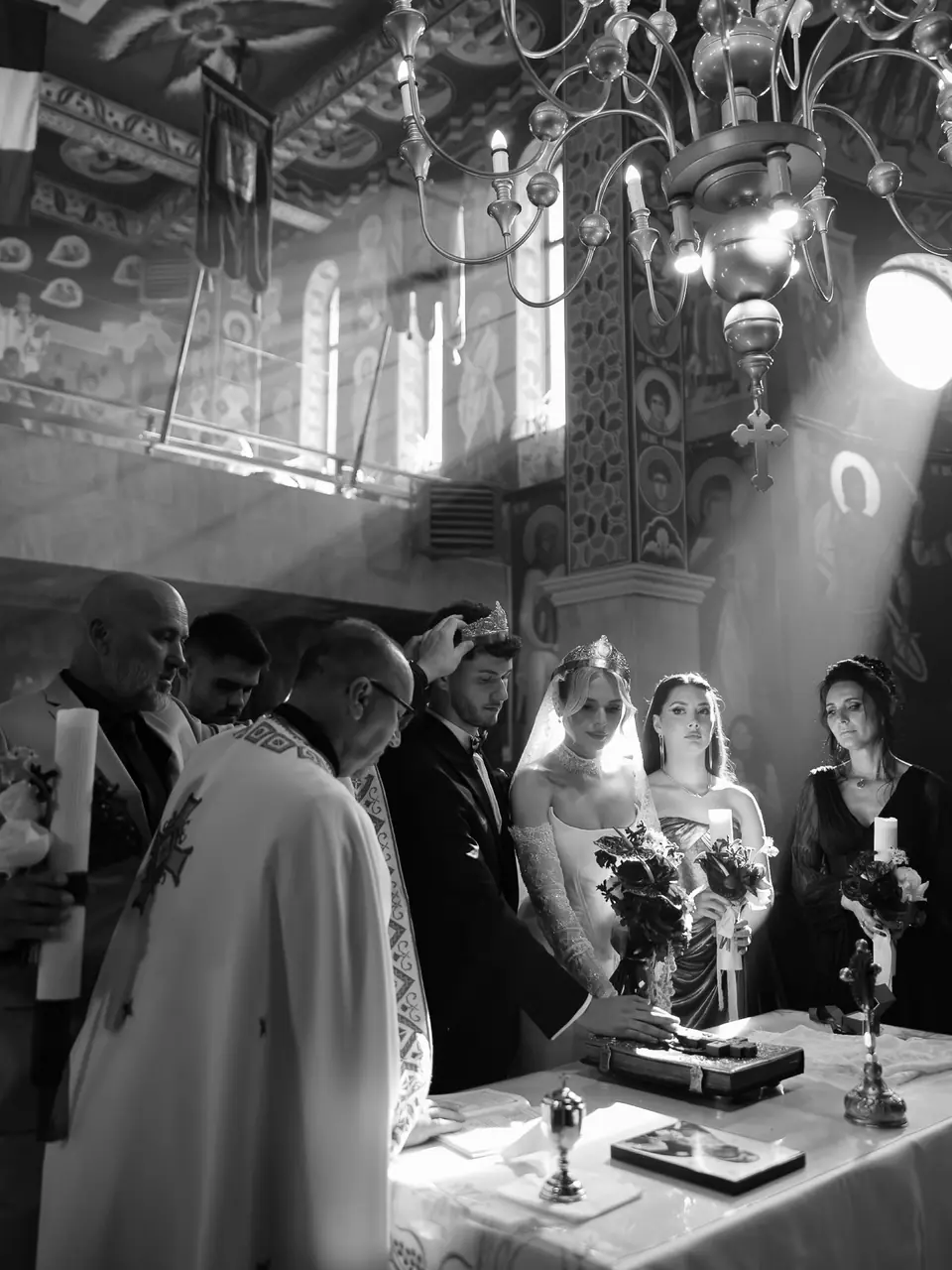 A black and white photograph of the Orthodox ceremony, light streaming across the couple