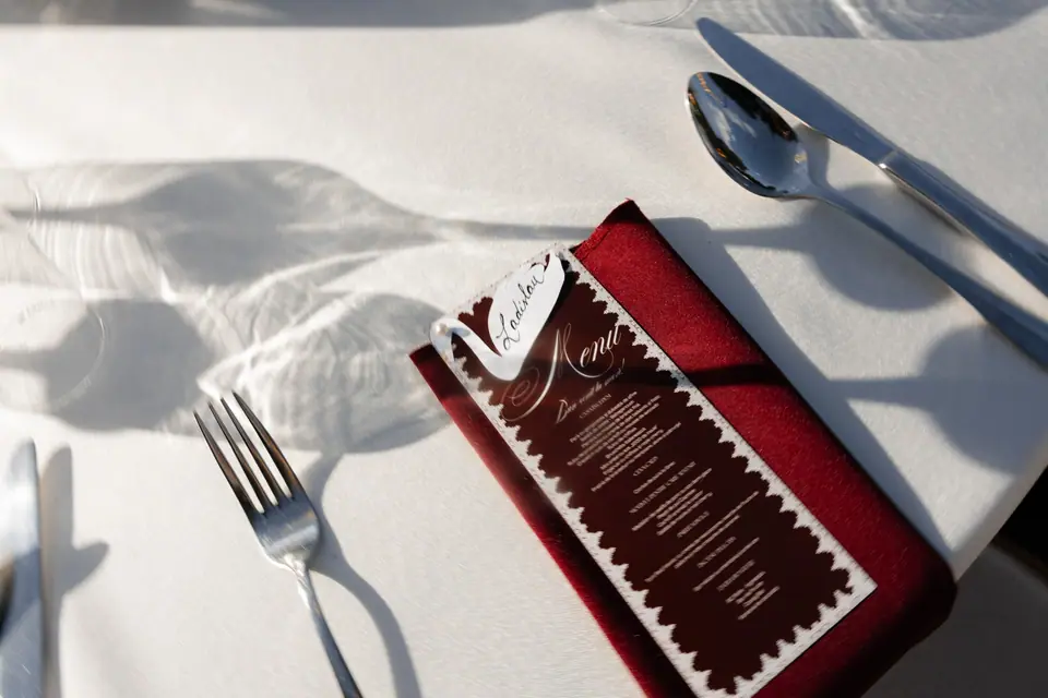 Close-up of a place setting with the menu on a burgundy napkin