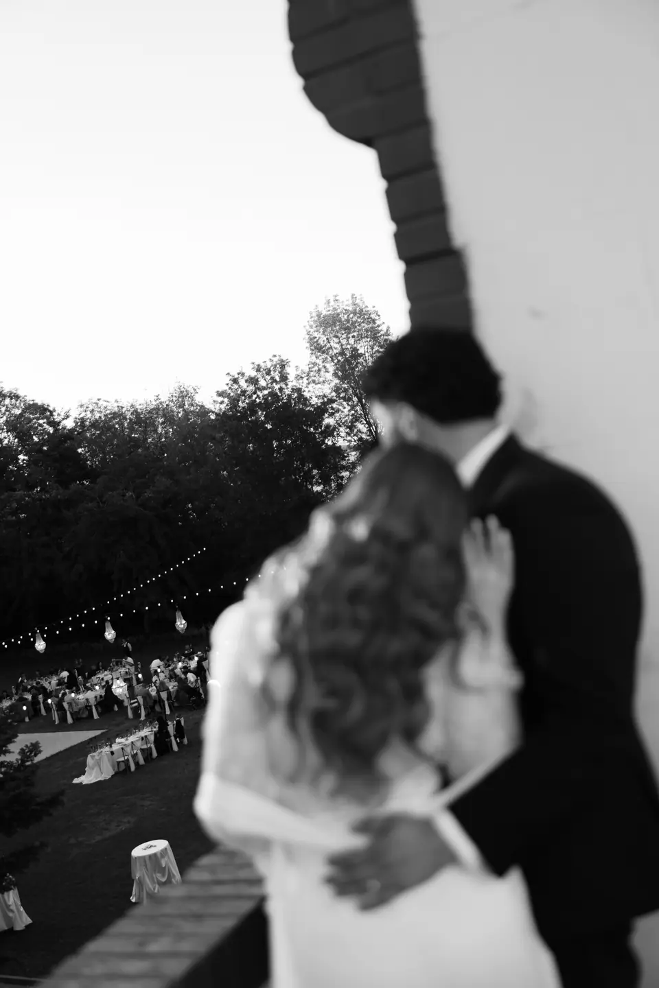 Black and white photograph of the couple embracing above the reception
