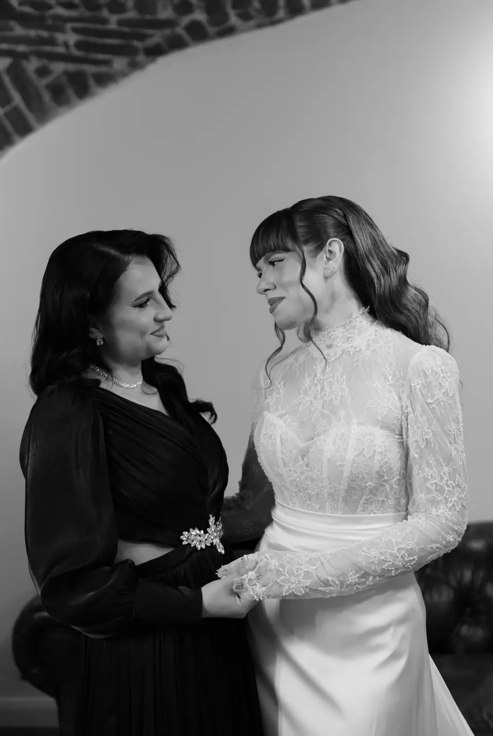 Black and white photograph of Bianca and a woman in black holding hands