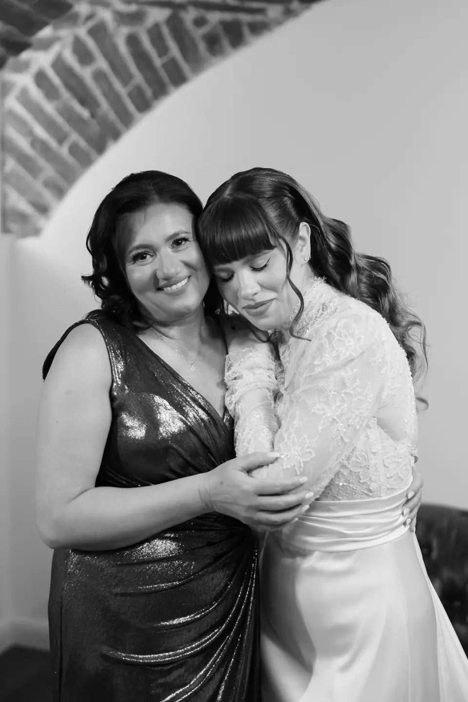Black and white photograph of Bianca hugging a woman in a sequinned dress