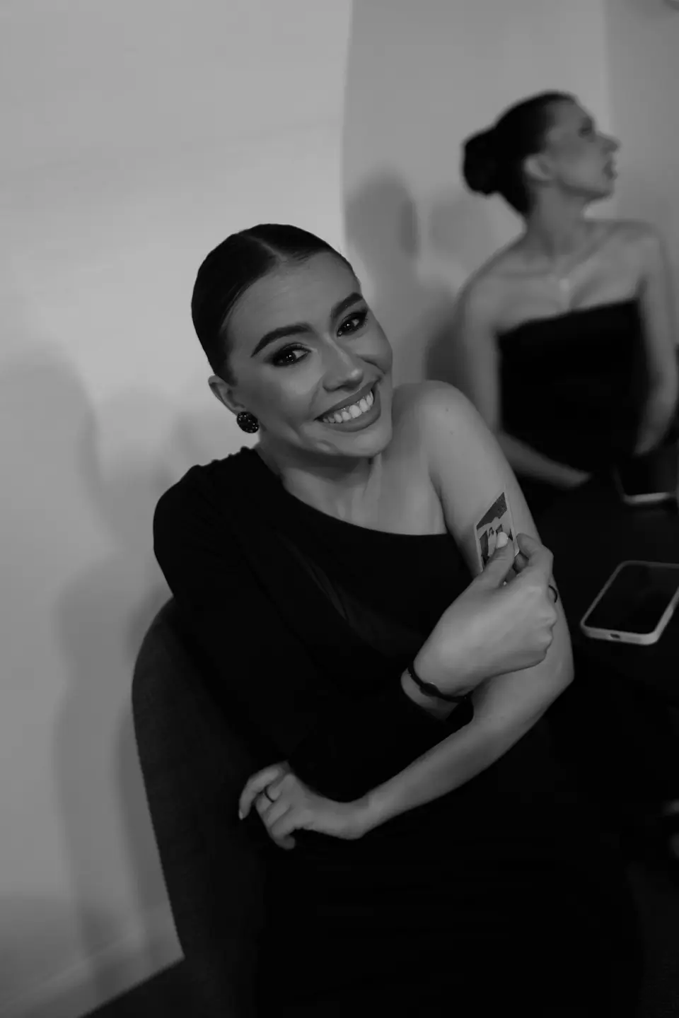 Black and white photograph of a smiling bridesmaid in black