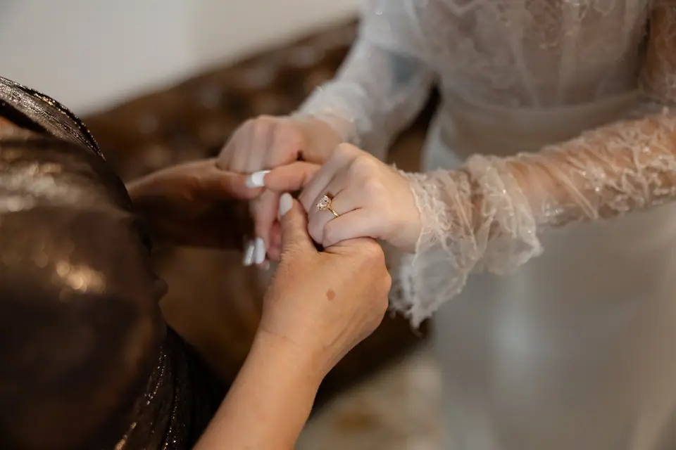 Two women holding Bianca’s hand, her engagement ring in view