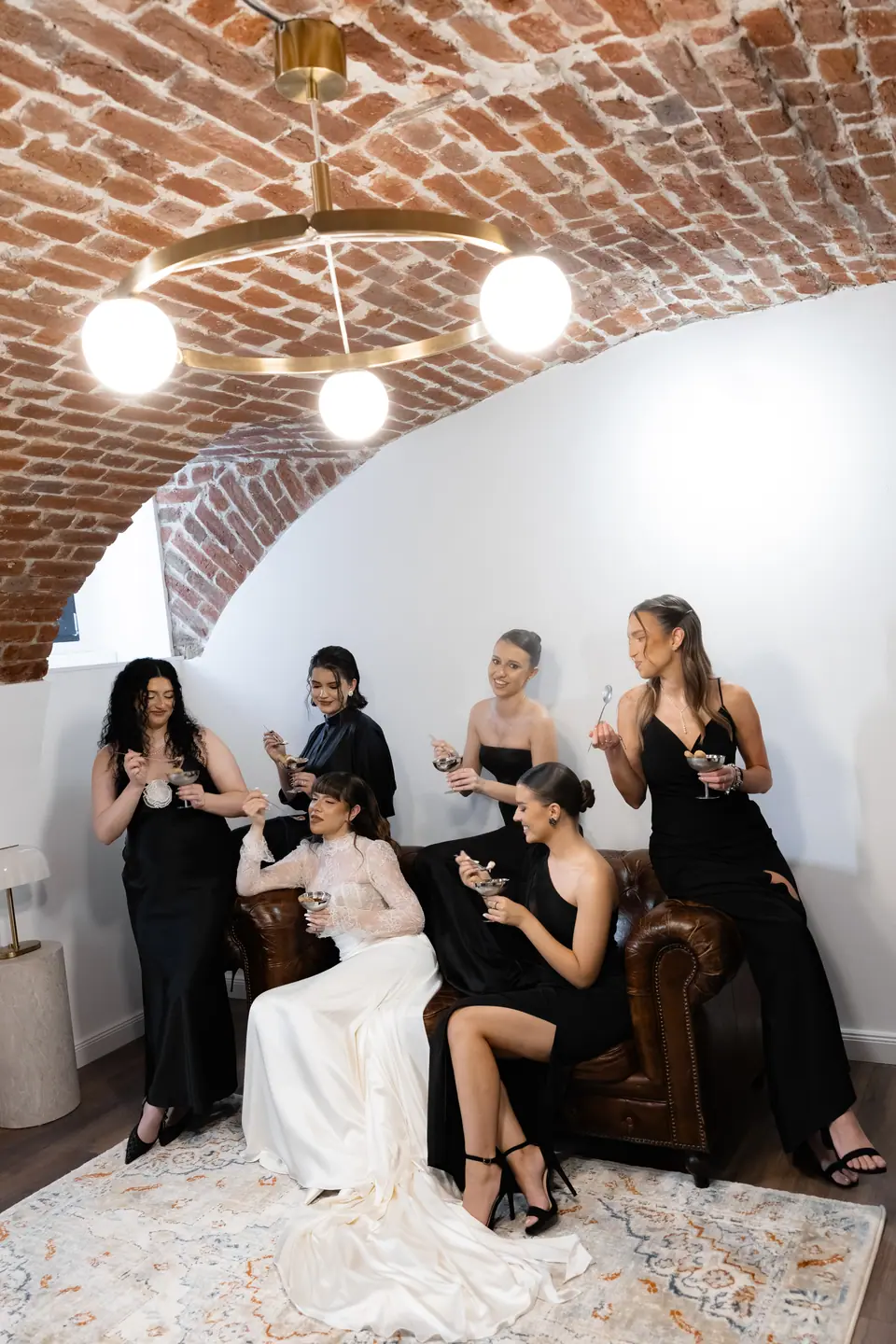 Bianca and her bridesmaids sharing tiramisu beneath the brick vault