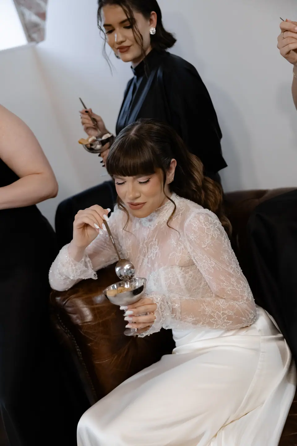 Bianca eating tiramisu from a coupe, a bridesmaid behind her