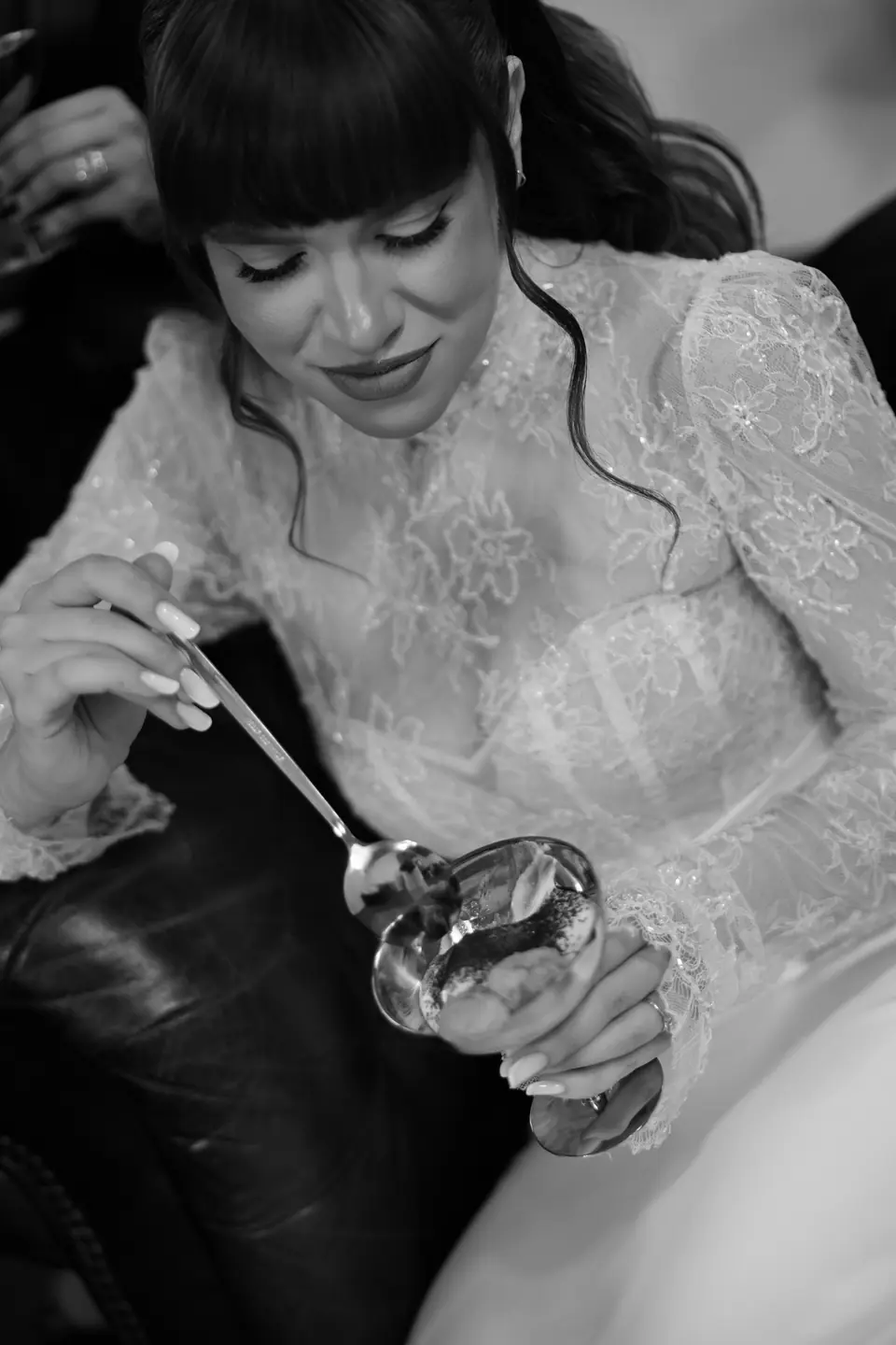 Black and white close-up of Bianca spooning tiramisu from a coupe