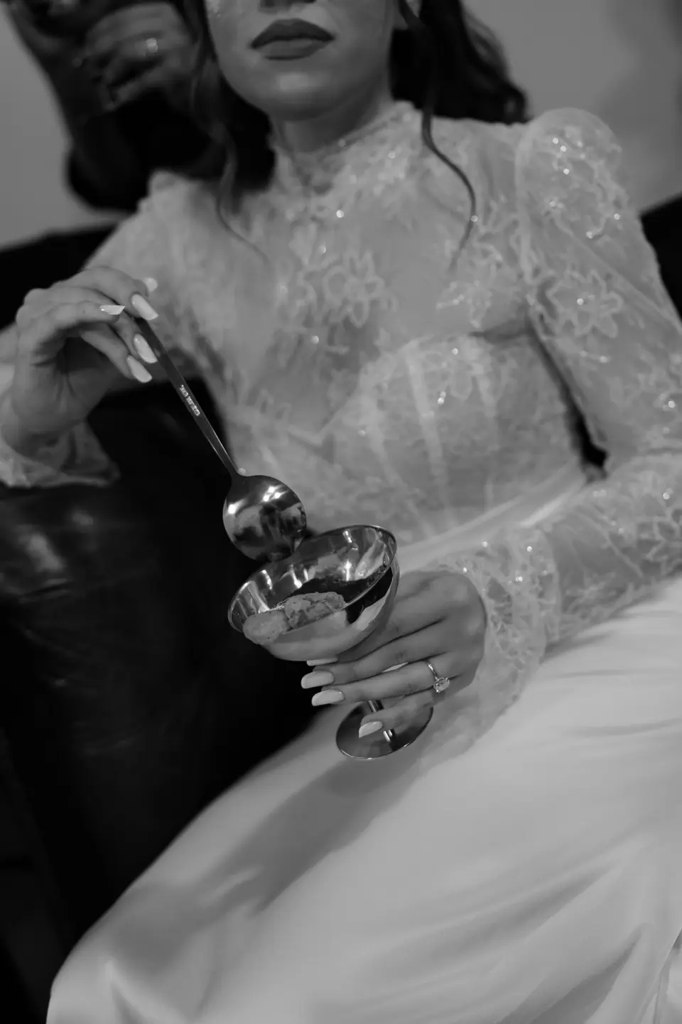 Black and white close-up of Bianca’s lace sleeve and spoon over the coupe