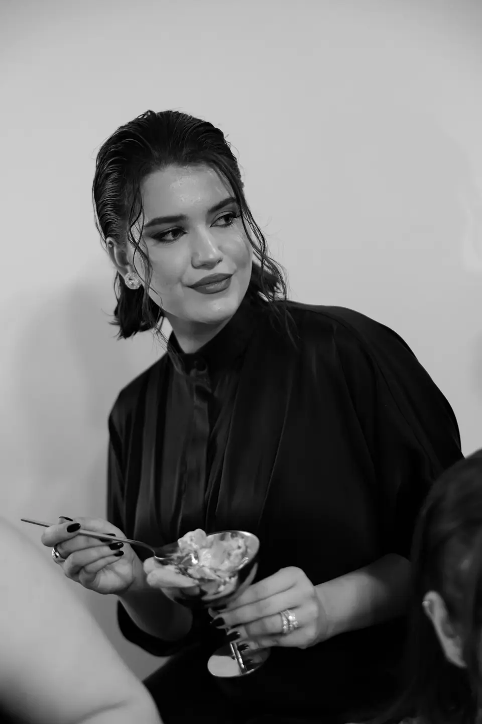 Black and white photograph of a bridesmaid in black with a coupe of tiramisu