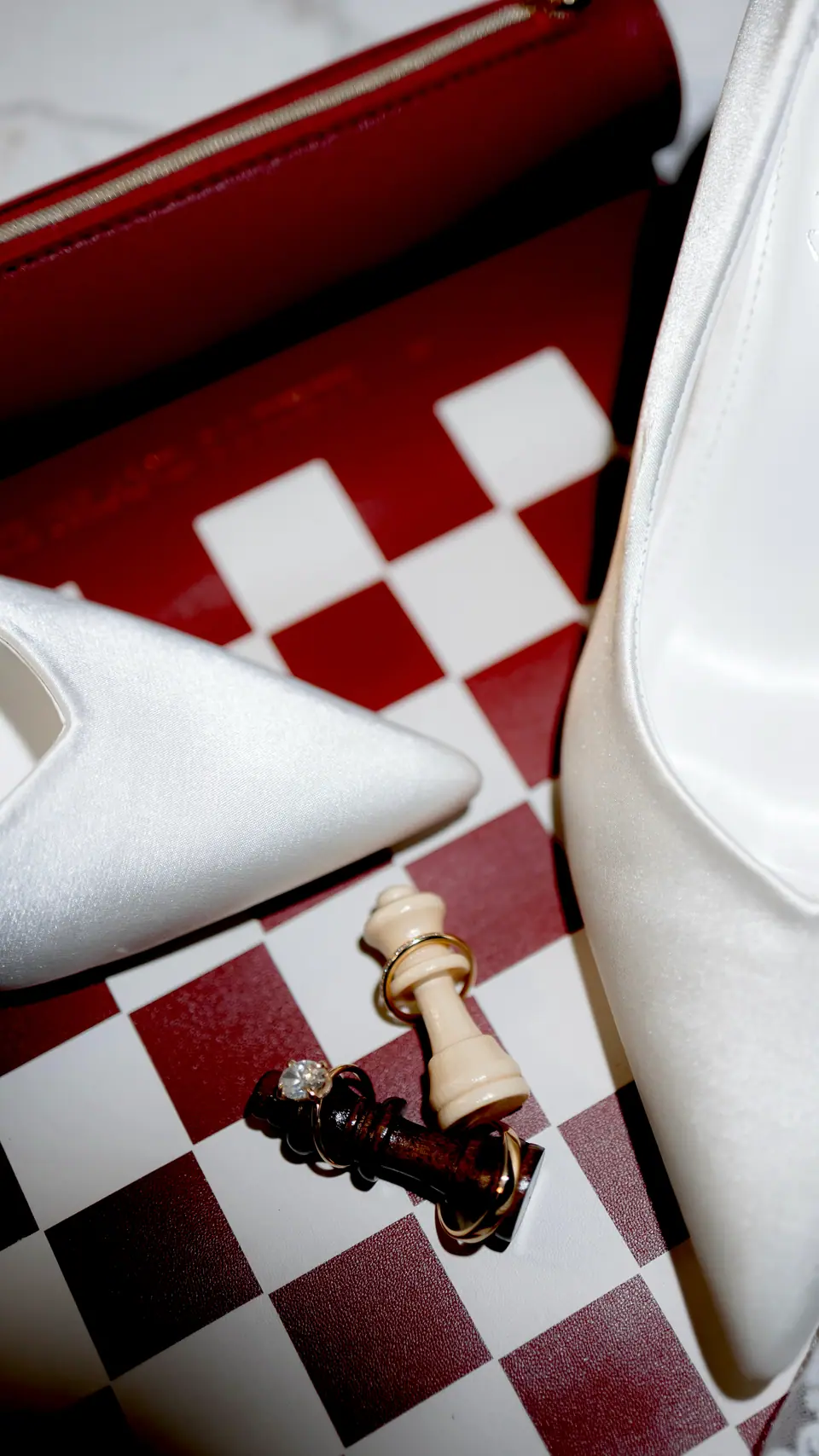 Bianca’s white heels and a chess king on the red and white board