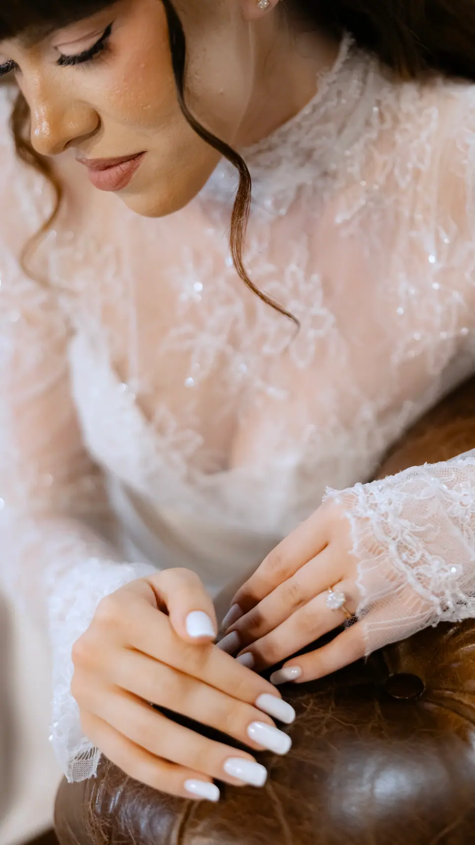Close-up of Bianca’s lace sleeves and ring as she leans on the chesterfield