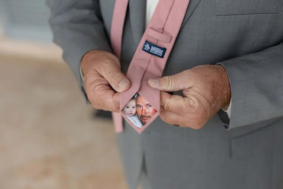 A pink tie turned over to show a sewn-in photo of a little girl with her father