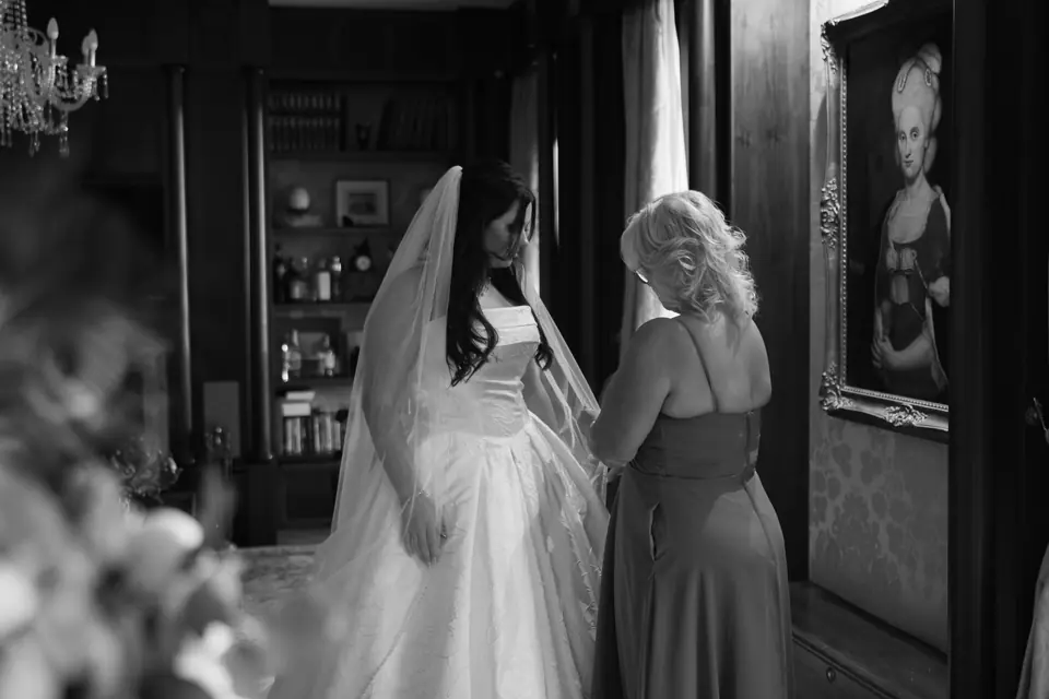 Black and white photograph of a woman helping Haley in a library with a portrait on the wall