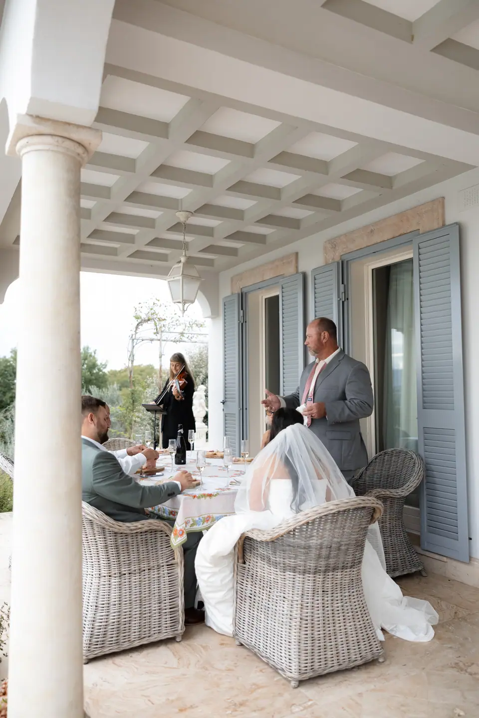 Haley, Zach and their families at lunch among wicker chairs on the terrace