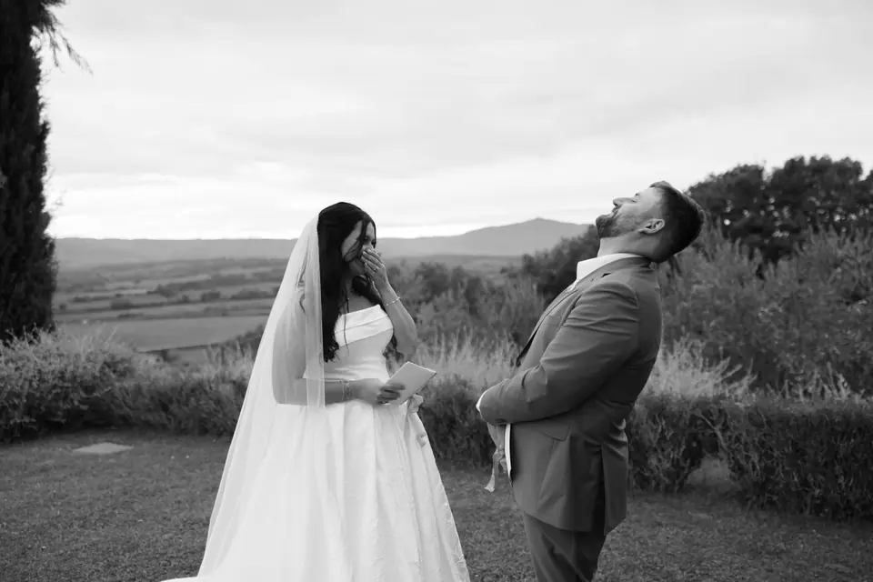 A black and white photograph of Haley and Zach laughing in a garden above the Umbrian hills