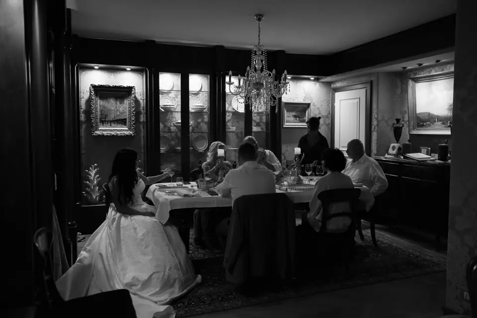 Black and white photograph of Haley, Zach and their families at dinner in the dining room