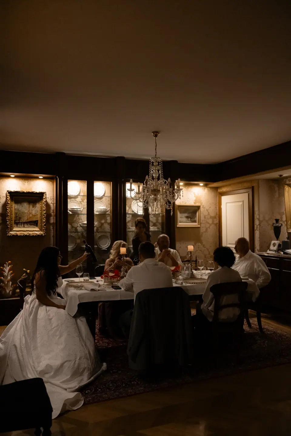 The candlelit dinner seen from the doorway, Haley at the head of the table