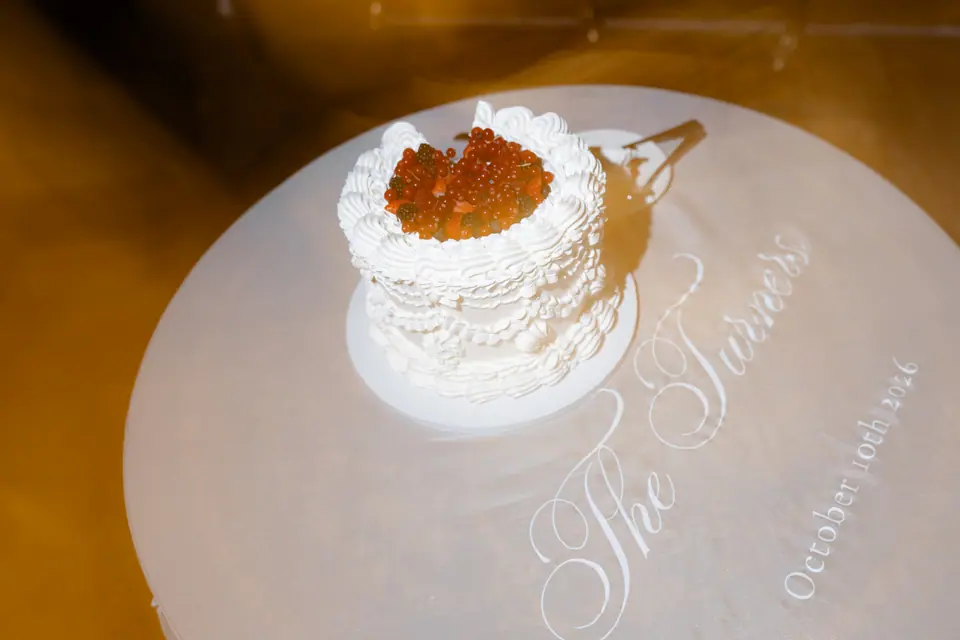 The berry cake glowing in warm light on the embroidered round table