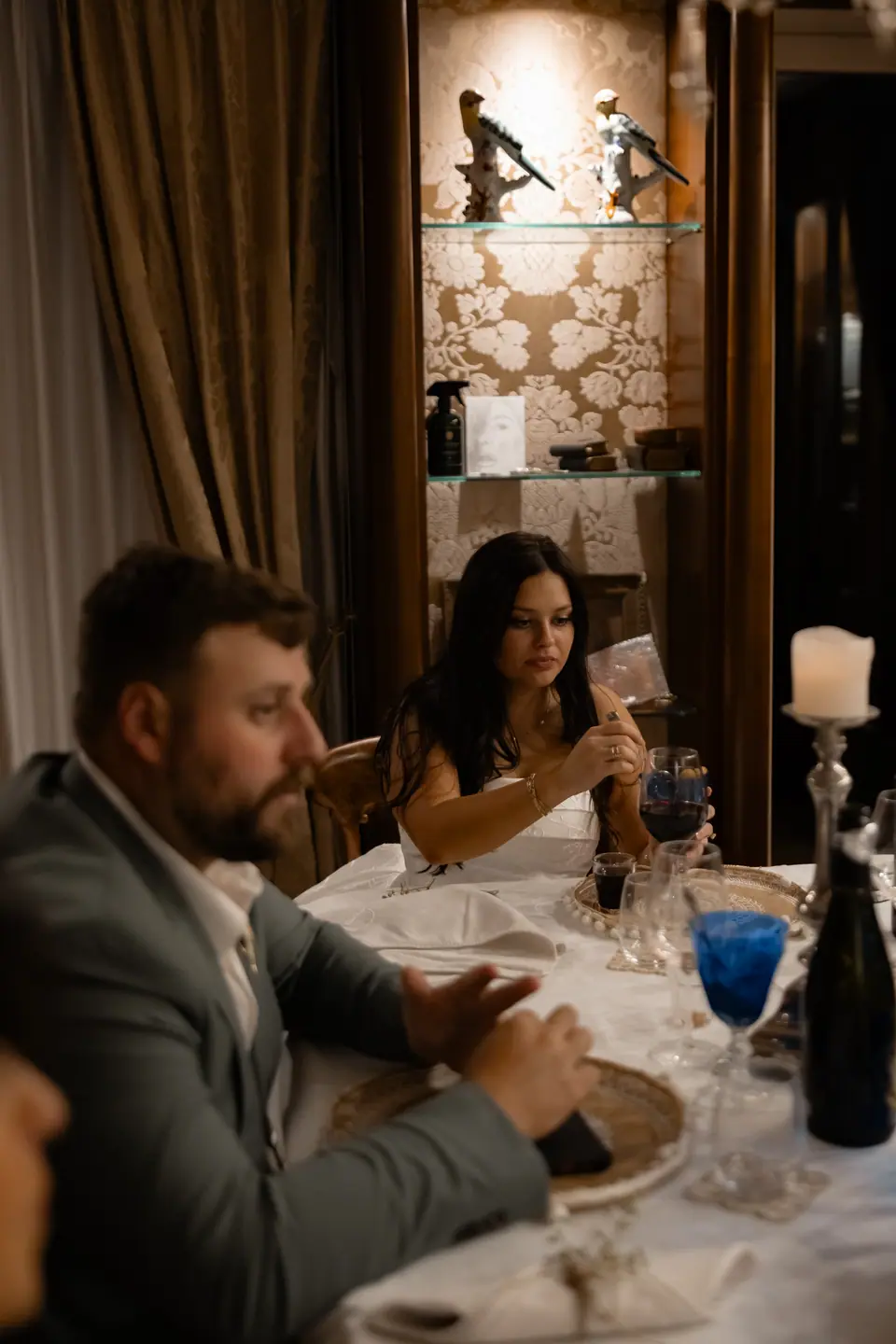 Zach and Haley at the candlelit dinner table with blue glasses and wine