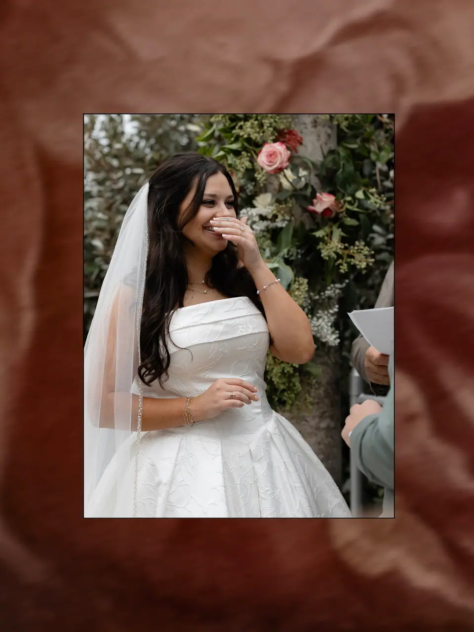 Haley laughing behind her hand during the ceremony, framed on a red floral ground