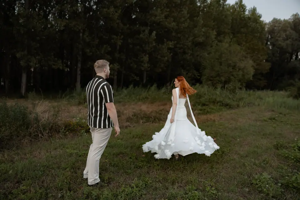 Kate’s dress swirling as she walks toward James across a green clearing