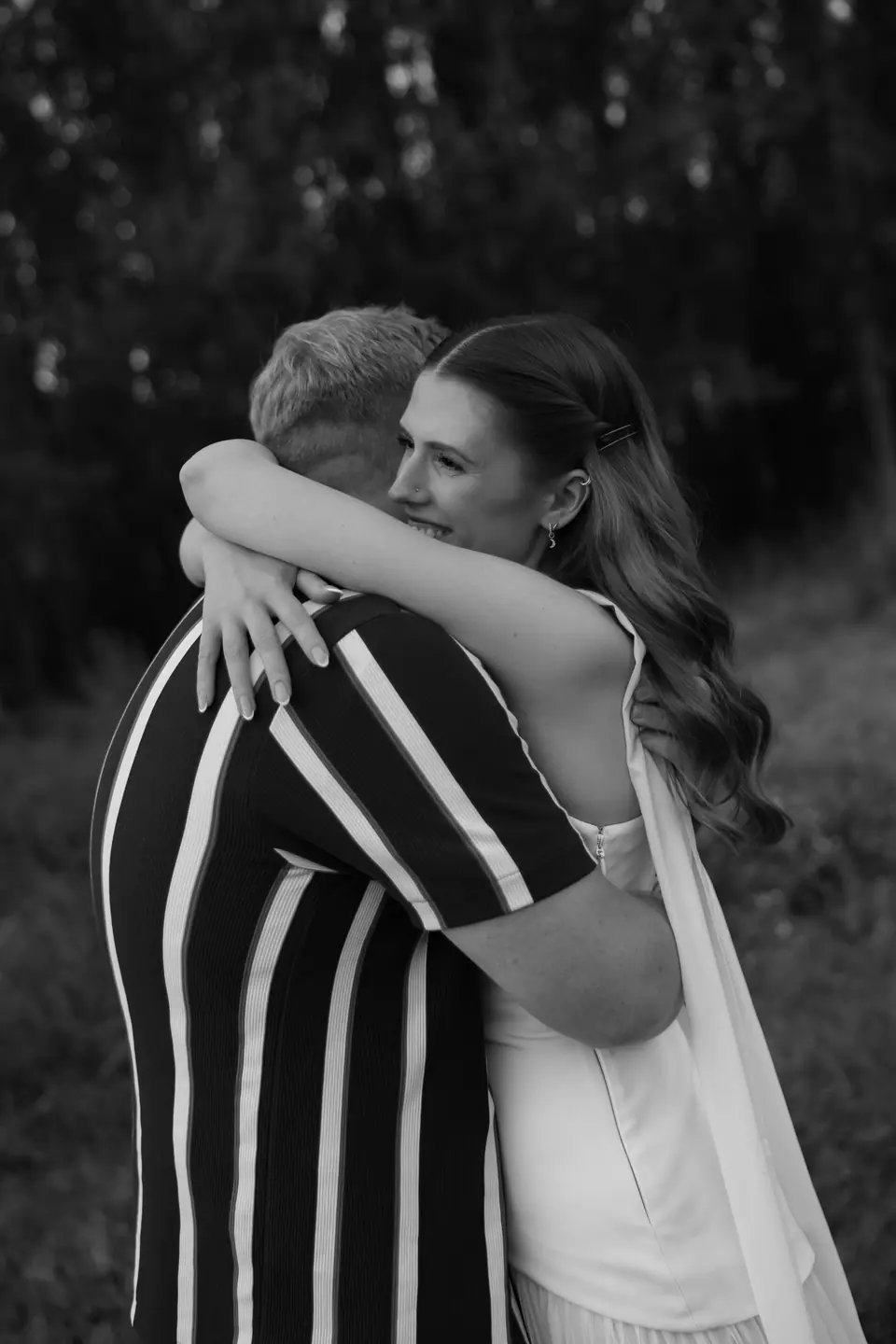 Black and white of Kate and James hugging, her scarf trailing behind her